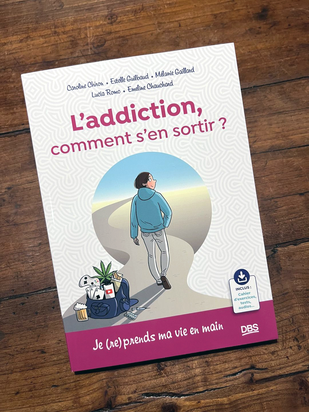 Photo du livre " L'addiction, comment s'en sortir ?" posé sur une table en bois